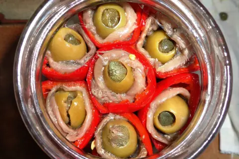 Peperoni sott'olio con acciughe e capperi, un antipasto saporito e colorato, pronto per essere gustato.