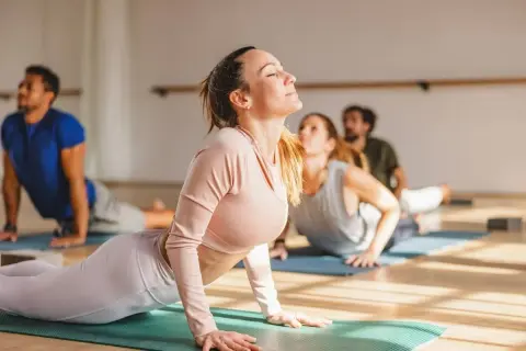 Cours de yoga en groupe, posture du cobra pour une respiration anti-stress.