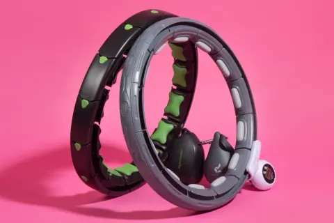 Zwei Hula Hoop Reifen mit Gewichten und Zählfunktion, einer davon ein Hula hoop mit ball testsieger.