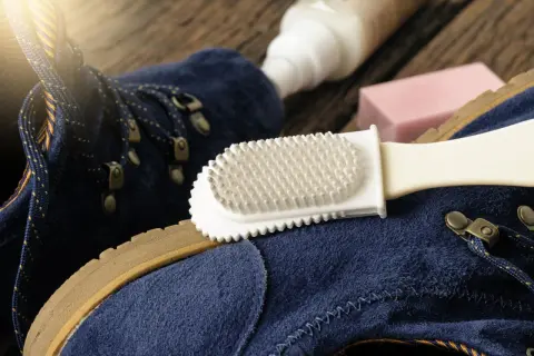 Pflege für deine leguano schuhe: Blaue Wildlederschuhe werden mit einer Bürste und Pflegeprodukten gereinigt.