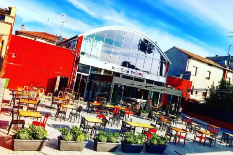 Birrificio Renton, una moderna hilltop brewery con tavoli all'aperto sotto un cielo azzurro.