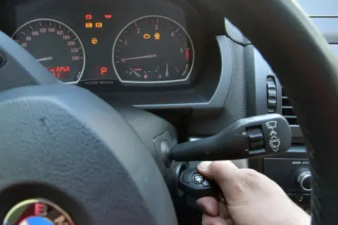 Ręka wkłada kluczyk do stacyjki, by dokonać kasowanie błędów. Na desce rozdzielczej świecą kontrolki.