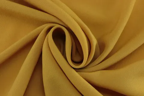 Złoty welur, miękki i lejący, układa się w eleganckie fałdy.