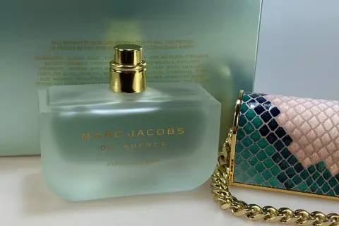 Flakon perfum Marc Jacobs Decadence Eau So Decadent obok ozdobnej torebki.