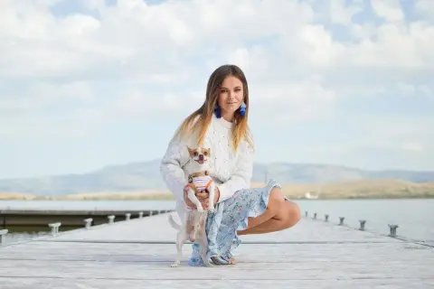Dziewczyna z psem na molo. Jej styl, jak znaleźć swój styl test, jest swobodny i kobiecy.