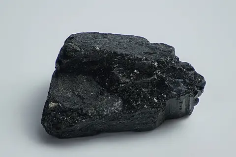Ein roher, glänzender schwarzer Achat, dessen Wirkung oft mit Schutz und Erdung assoziiert wird.
