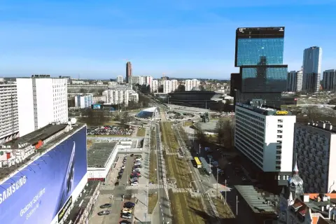 Widok na nowoczesne centrum Katowic z wieżowcami i drogą w tle.