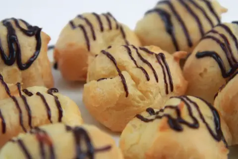 Montón de profiteroles con glaseado de chocolate. ¿De donde son los profiteroles? ¡De Francia, por supuesto!