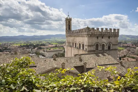 Gubbio da vedere: imponente Palazzo dei Consoli domina il borgo medievale con i suoi tetti in cotto e le colline umbre sullo sfondo.