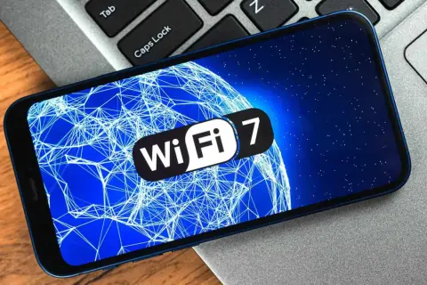 Smartphone affichant le logo Wi-Fi 7 sur un fond bleu étoilé, symbolisant la prochaine génération de connectivité sans fil, potentiellement en 6 GHz.
