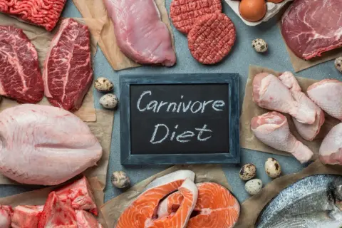 Różnorodne mięsa, ryby i jaja na stole. Tabliczka z napisem "Carnivore Diet" sugeruje potencjalne dieta karniwora efekty.