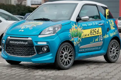 Niebieski czterokołowiec lekki Ligier JS 50 z napisem "WOW" i informacją o cenie.