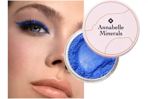 Oko podkreślone intensywnym, niebieskim eyelinerem. Obok słoiczek z sypkim, niebieskim cieniem Annabelle Minerals.