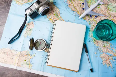 Karte, Kompass, Notizbuch, Kamera, Flugzeug und Glas – alles bereit für die weltreise 1 jahr.