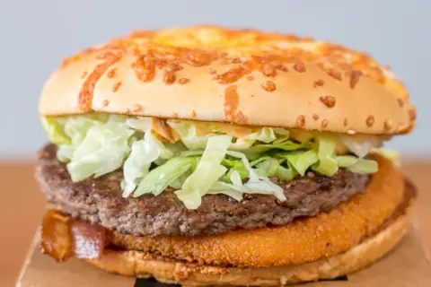 Drwal z kurczakiem, czyli soczysty burger z chrupiącym kurczakiem, wołowiną i serem, gotowy do zjedzenia.