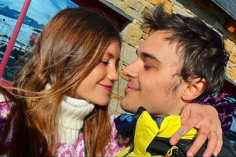 Eduardo Pérez-Cabrero y su pareja, una joven con cabello castaño, se miran tiernamente con nieve de fondo.