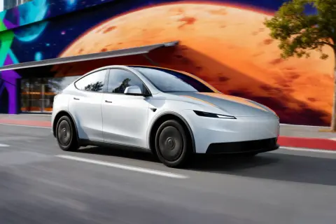 Biała Tesla Model Y pędzi po drodze. Zastanawiasz się, ile kosztuje najnowsza Tesla?