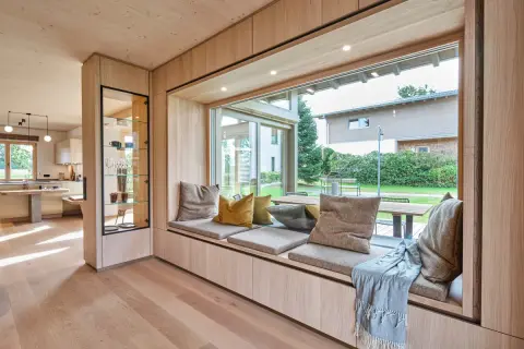 Gemütliche **Ideen für Sitzfenster**: Ein einladender Bereich mit Kissen und Decke lädt zum Verweilen ein, während der Blick ins Grüne schweift.