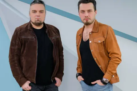 Dwóch mężczyzn, bracia, pozuje do zdjęcia w skórzanych kurtkach.