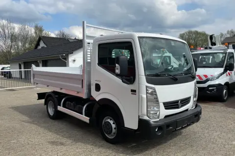 Biały Renault Maxity z otwartą skrzynią ładunkową stoi na placu.