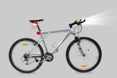 Silver mountainbike med fram- och bakljus samt ringklocka. All cykel utrustning är på plats för en säker tur.
