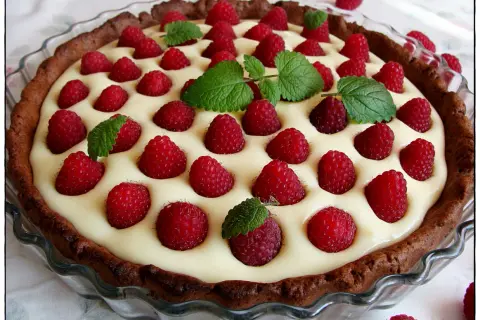 Tarta z mascarpone i białą czekoladą, ozdobiona malinami i miętą. Kwestia smaku, która zachwyca!