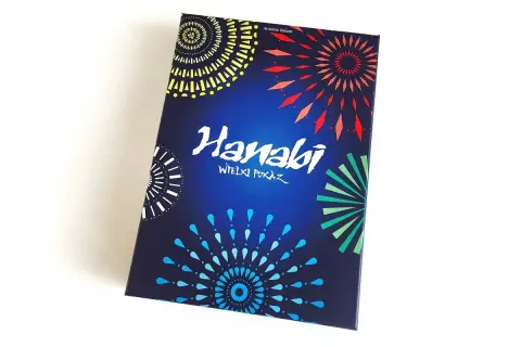 Pudełko gry karcianej Hanabi z kolorowymi fajerwerkami na ciemnoniebieskim tle.