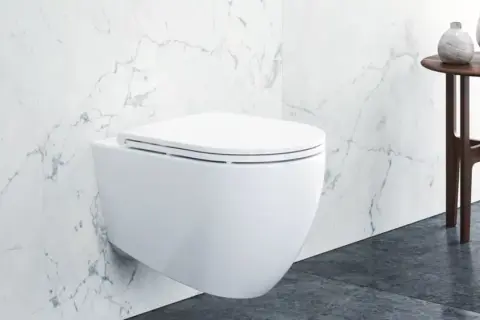 Modernes wandhängendes WC mit Klodeckel montieren. Marmorfliesen und ein Beistelltisch mit Vasen im Hintergrund.