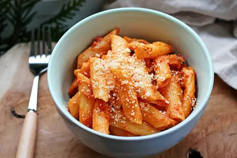 Penne z sosem pomidorowym, posypane parmezanem. Idealne danie z pomidorkami datterini.