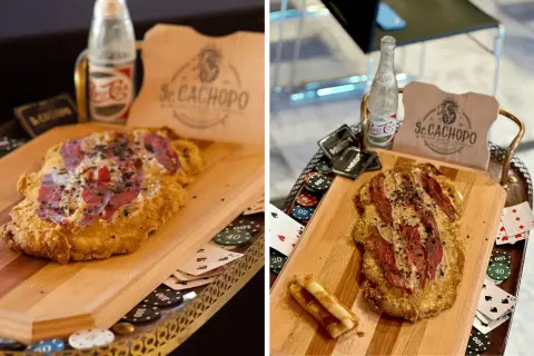 El cachopo Zaragoza, un plato crujiente con jamón y queso, servido con fichas de póker y una botella de refresco.