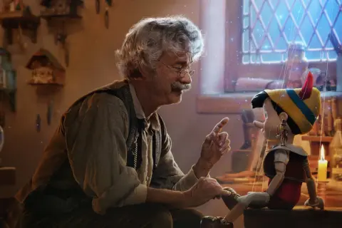 Gepetto pratar med Pinocchio, en docka som ser ut att vara från klassiska familjefilmer. En magisk stämning med gnistrande ljus.