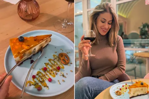 Kobieta cieszy się deserem w jednej z najlepszych restauracji w Sopocie. Sernik z musem mango i owocami wygląda pysznie.
