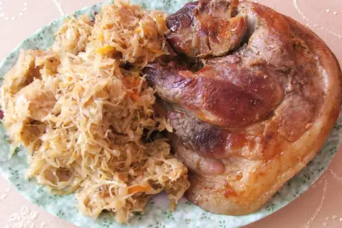 Pyszna golonka w kapuście, pieczona do perfekcji, z chrupiącą skórką i soczystym mięsem. Idealny polski obiad.