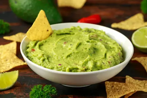 Pyszne guacamole przepis na domową przekąskę. Kremowe awokado, świeża limonka i chrupiące nachos.