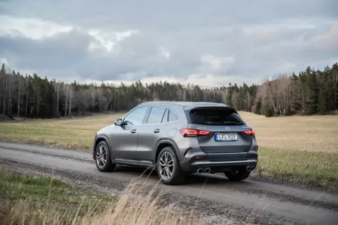 Grå Mercedes GLA 45 AMG på grusväg i skogen, med molnigt väder. Kanske ett problem med terrängkörning?