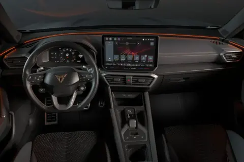 Interior del Cupra Formentor con pantalla táctil, volante deportivo y luces ambientales naranjas.