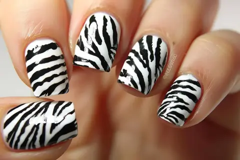 Paznokcie motyw zwierzęcy w stylu zebra. Czarne pasy na białym tle tworzą dziki wzór.