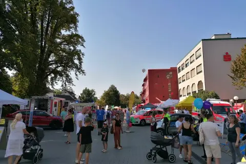 Menschen genießen das Stadtfest Bergisch Gladbach bei Sonnenschein. Einsatzfahrzeuge und Stände säumen die belebte Straße.