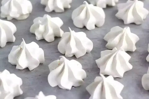 Une belle **recette meringue** : des petits nuages blancs et aériens disposés sur une plaque.