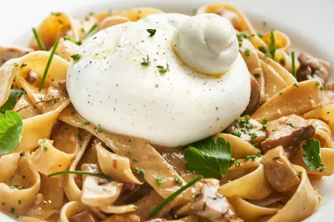 Pasta mit Pilzen und cremiger Burrata, ein köstliches italienisches Gericht.