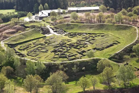 Vista aérea del castro de Viladonga, con sus murallas y restos de edificaciones de piedra cubiertos de hierba.