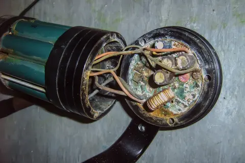 Uszkodzona instalacja elektryczna w domu, objawy: spalone przewody, skorodowane kondensatory i cewka.
