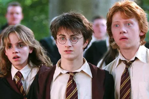Harry, Ron i Hermiona w szkolnych szatach, gotowi na kolejne przygody w świecie magii. To początek ich historii, kluczowy moment w harry potter chronologia.