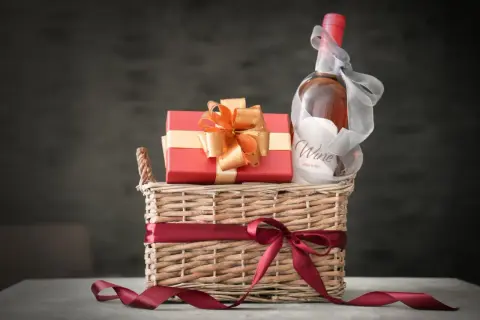 Elegancki kosz prezentowy z butelką wina i czerwonym pudełkiem, idealny jako dodatek do kosza prezentowego.