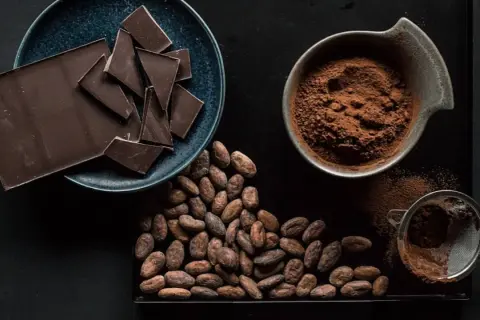 Tableta de chocolate, cacao en grano y polvo de cacao, mostrando diferentes tipos de chocolate.