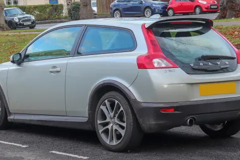 Srebrne Volvo C30 z charakterystycznym tyłem i spoilerem, zaparkowane na ulicy.