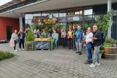 Eine Gruppe genießt Wein vor dem Meersburger Winzerverein. Herzlich willkommen!