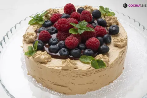Tarta de moka cubierta de crema de café, decorada con frutos rojos, arándanos y hojas de menta. ¡Una delicia!