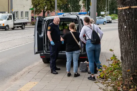 Strażnik miejski rozmawia z kobietami obok radiowozu. Może to być interwencja dotycząca zakłócania ciszy nocnej, wezwanie policji było konieczne.