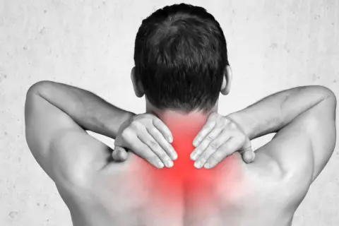 Mann mit Händen im Nacken, rote Schmerzstelle deutet auf Upper Cross Syndrom hin.